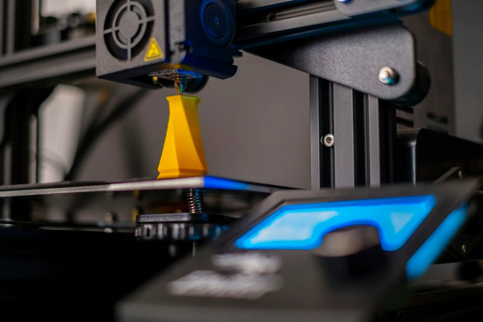 Close-up of a 3D printer in operation — the FDM printer that produces PLA / PETG bell parts for a printed train horn