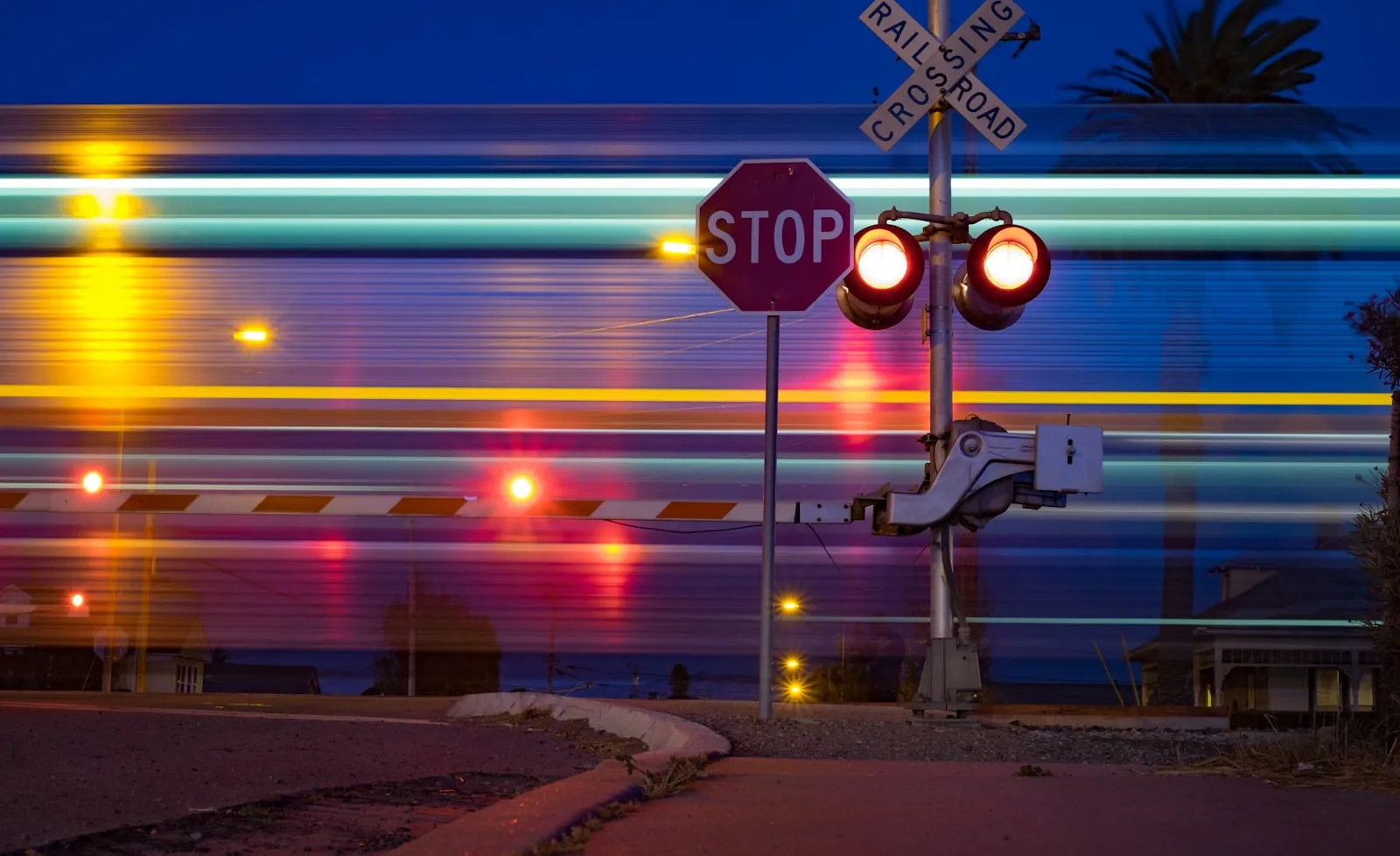 Railroad crossing stop sign at night — the public grade crossings where the FRA horn pattern is required