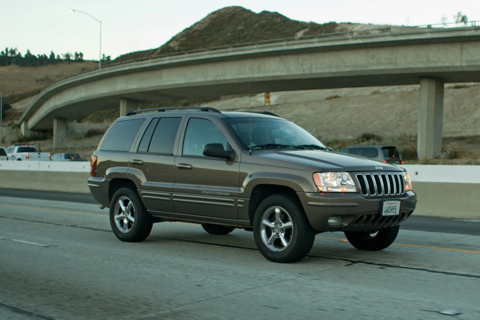 Brown Jeep Grand Cherokee on highway — Grand Cherokee SUV install context