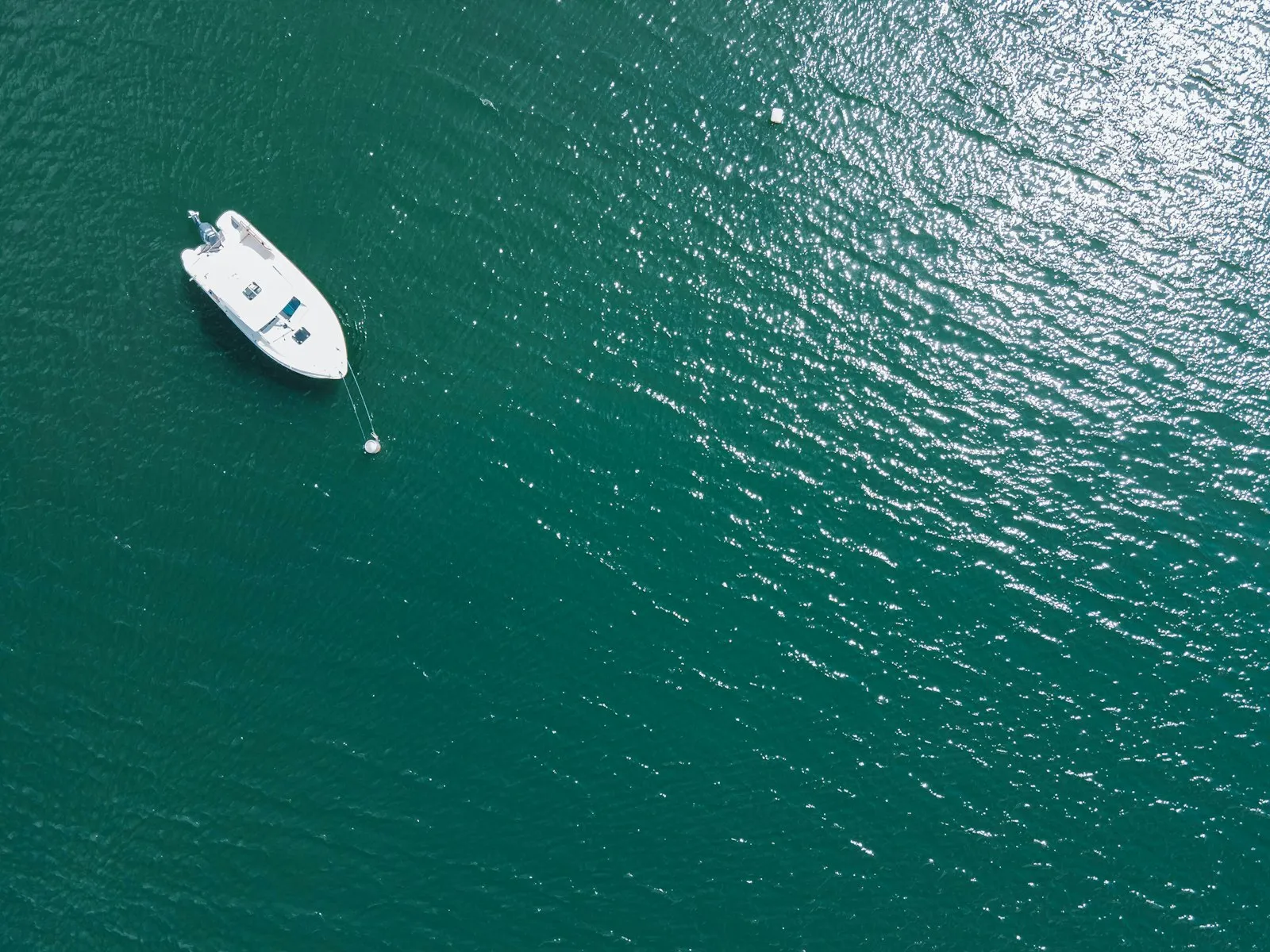 A small boat floating on top of a large body of water