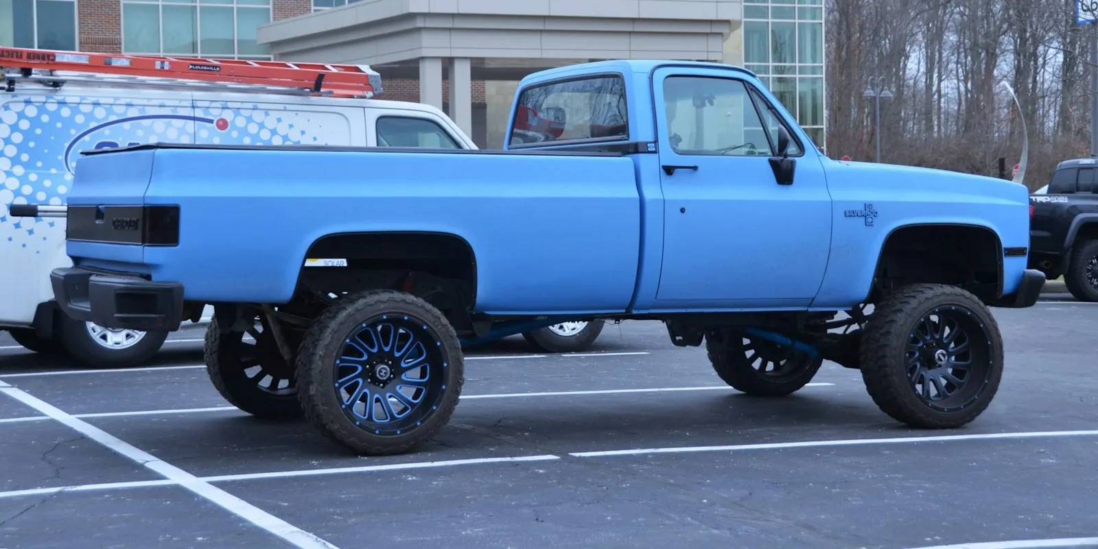 Mid 1980's Chevy C10 Square Body 4x4 pickup with lift kit and wheels and tires in Flat pastel blue