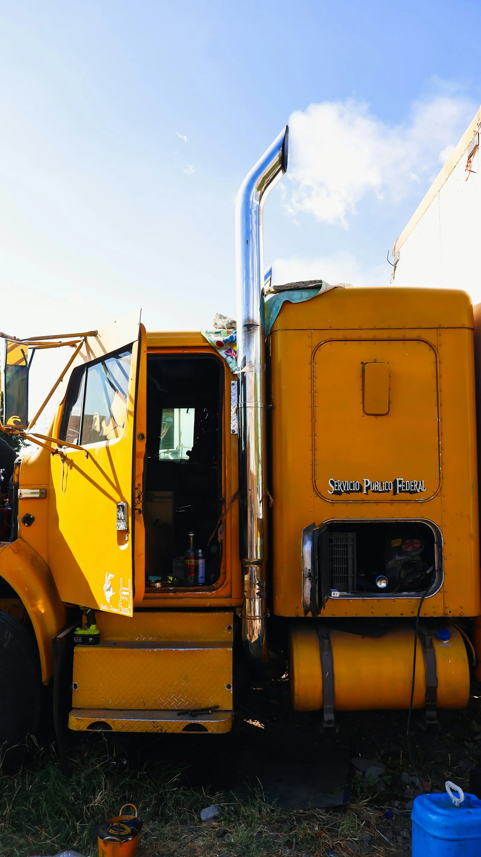 Yellow semi-truck with open doors and exhaust — Class 8 install context for United Pacific chrome zinc-alloy trumpets