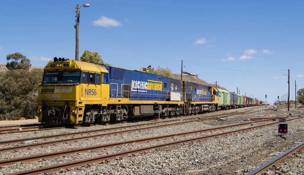 Freight train locomotive pulling cars down the main line