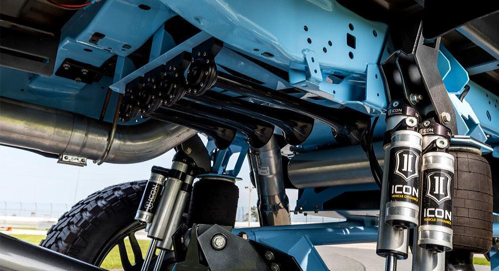 Train horn kit components mounted under a lifted truck's frame