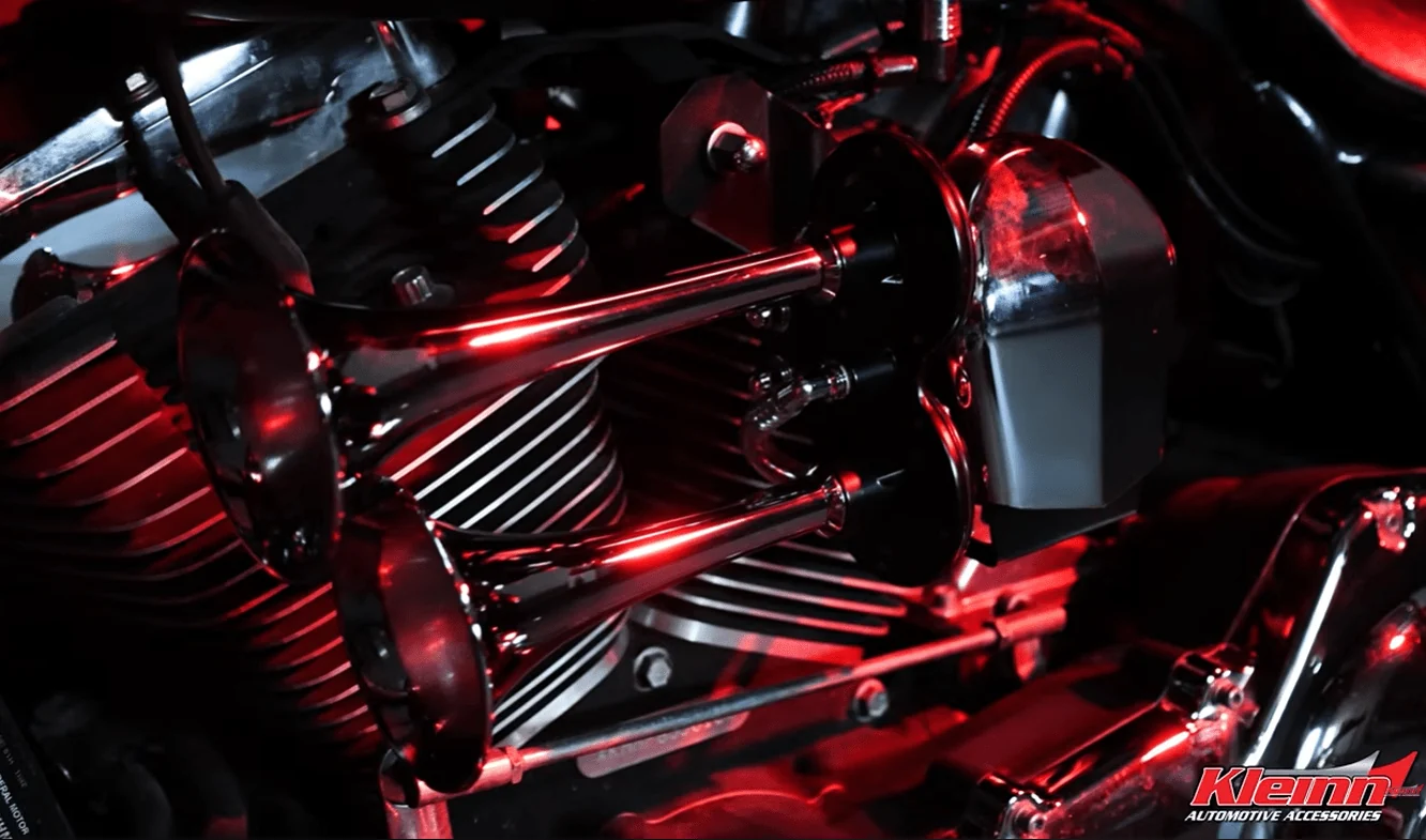 Kleinn HOGKIT-1 installed under the cowbell cover on a Harley-Davidson V-twin, shown in red lighting